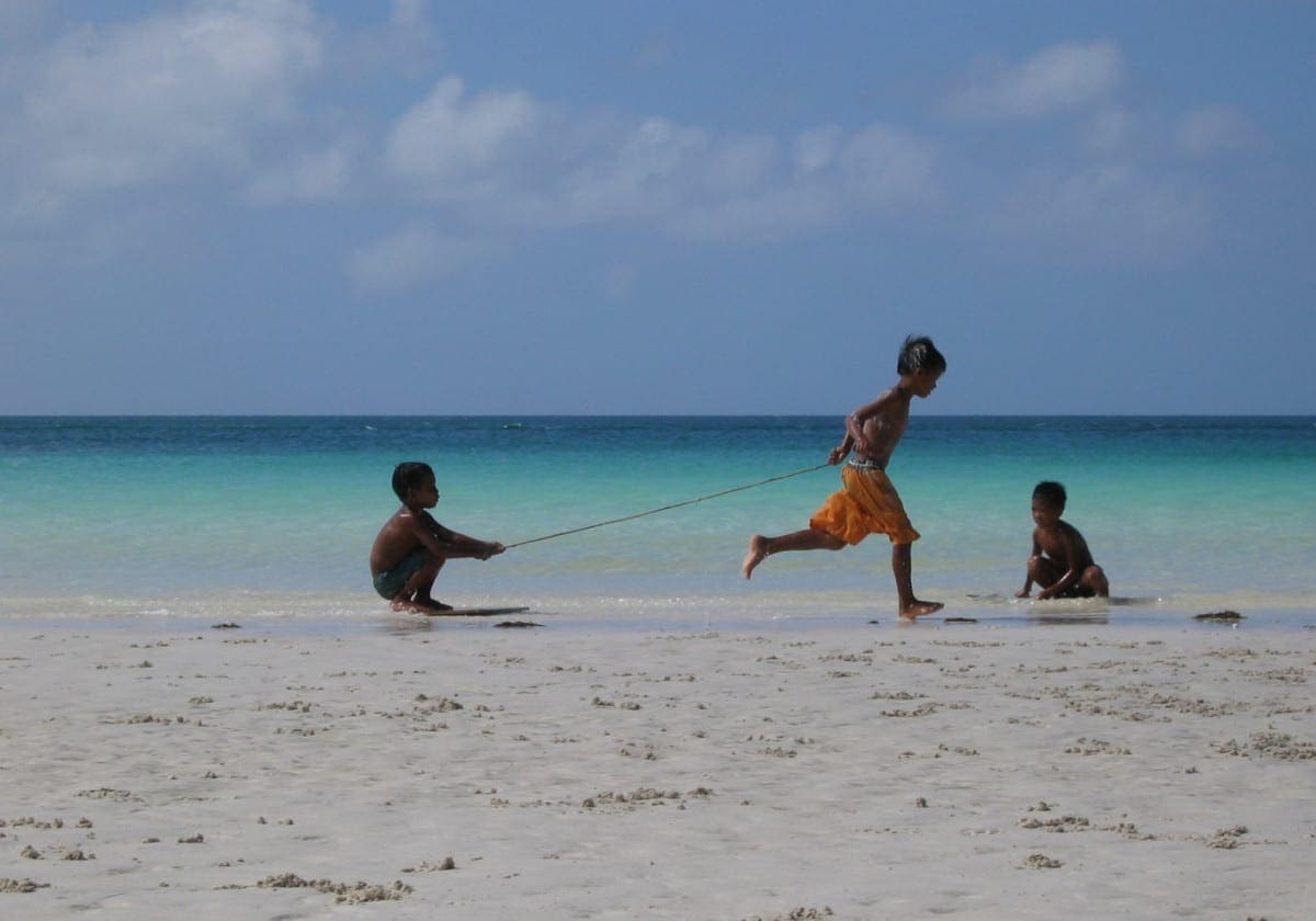 Glade børn der leger på stranden