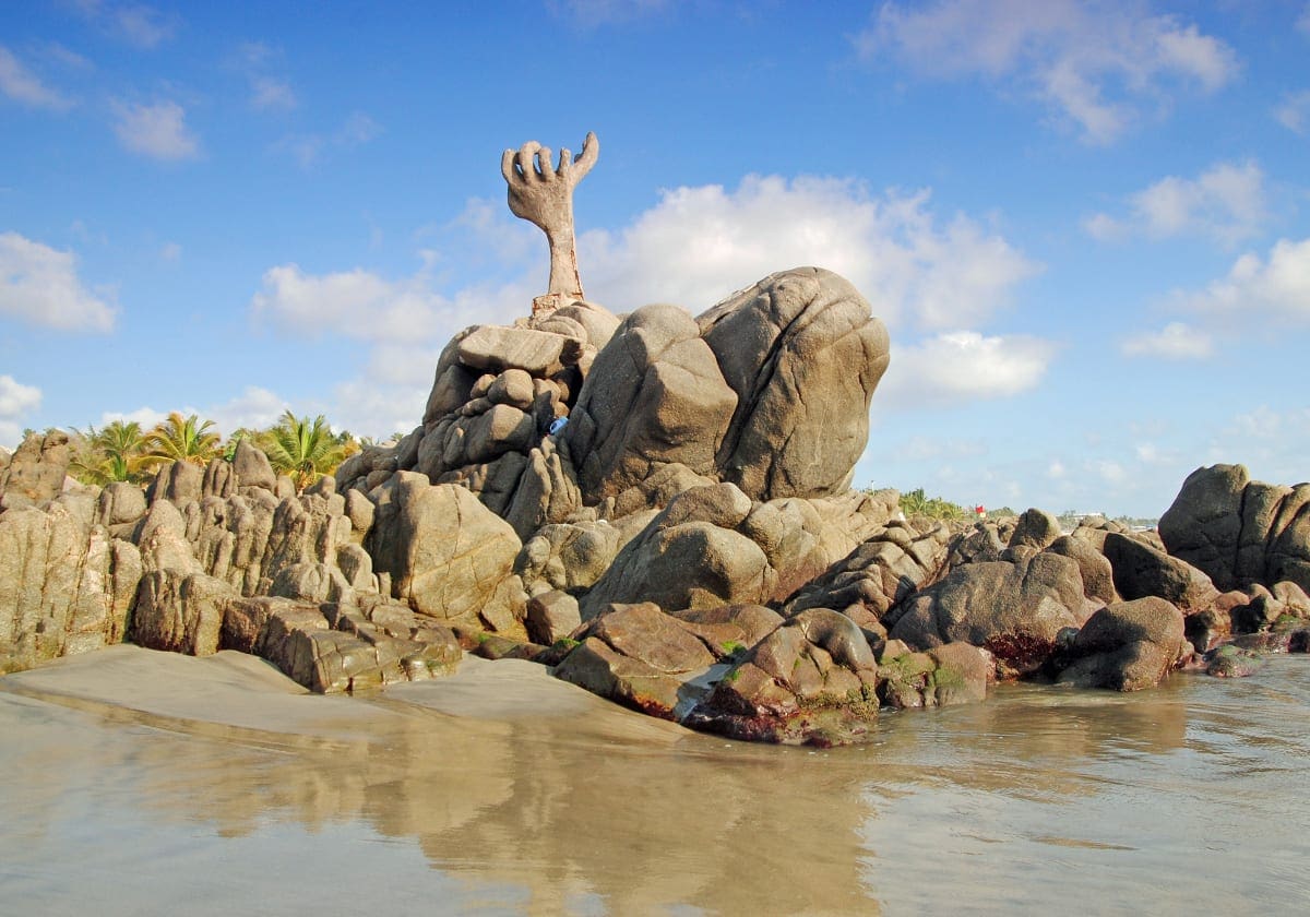 Den sjvoe hÃ¥ndskulptur pÃ¥ stranden