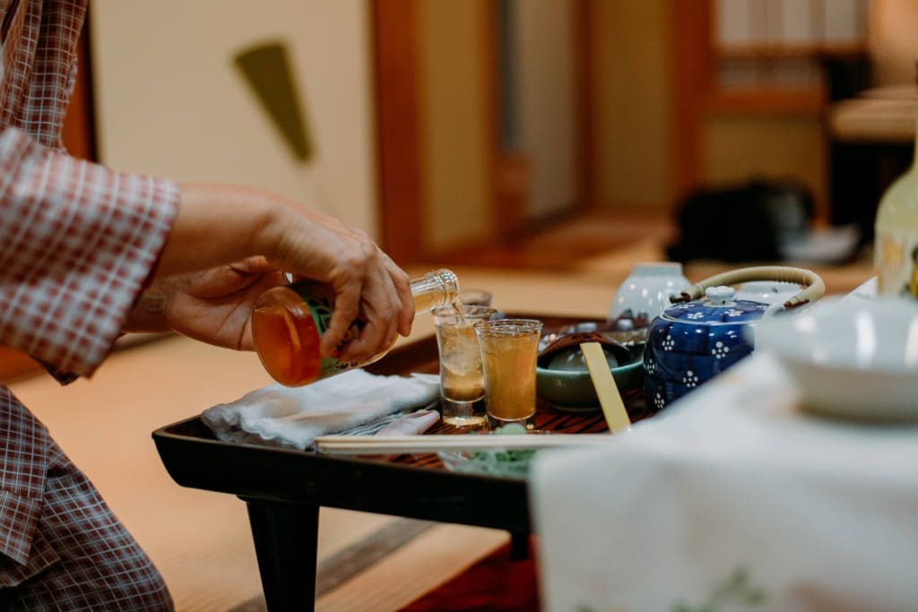 cropped-hands-pouring-two-shots-of-sake-2026-01-07-05-41-44-utc (1)